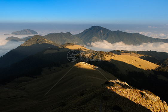 日落的美丽高山和金色草原蓝色环境地平线农村天空旅行晴天森林场地木头图片