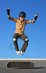 从滑板上跳出男孩跳高图片