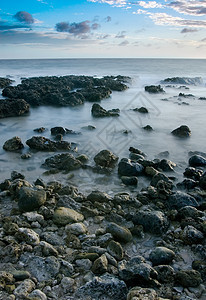 珊瑚礁海岸线的日落沿海天空风景日出蓝色旅行岩石支撑天堂游客图片