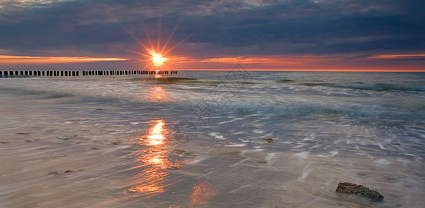 日落石头太阳木头海浪图片