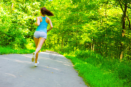 青年妇女户外健身慢跑成人行动慢跑者身体训练赛跑者树木火车图片
