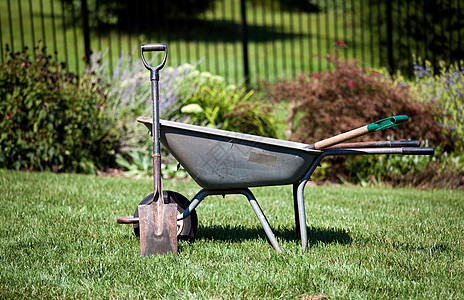 轮轴和黑桃灰色独轮车院子工具绿色工作大车花坛草地公园背景图片
