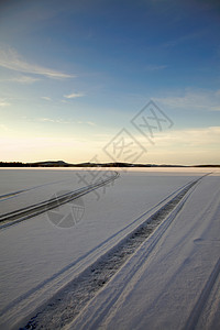 积雪中的轨迹摩托天空季节雪地蓝色太阳小路场景雪道图片