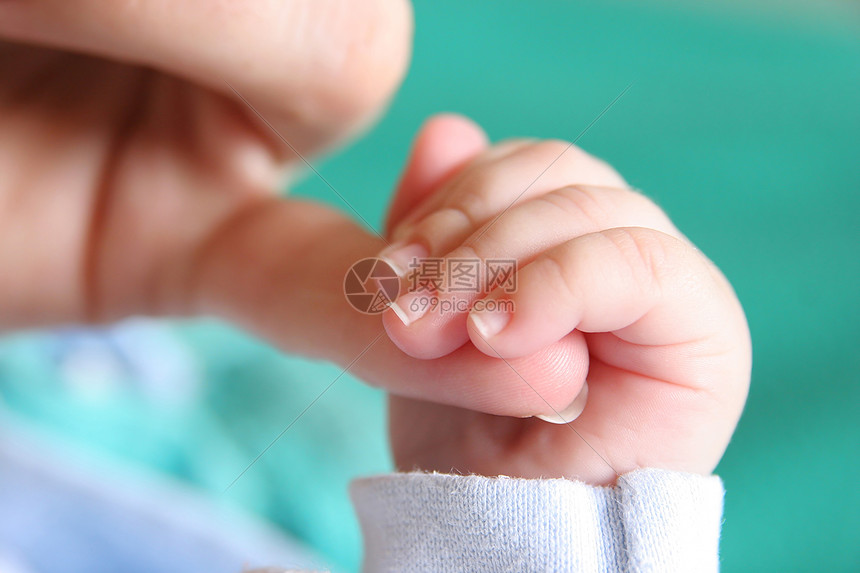 新出生婴儿的手握着母亲的手指孩子木乃伊青年皮肤母性家庭男人生活培育指甲图片