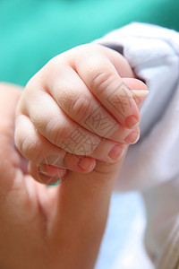 新出生婴儿的手握着母亲的手指青年男人孩子生活父母木乃伊帮助培育指甲皮肤图片