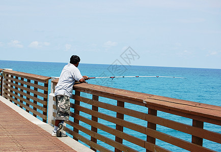 男子在码头捕鱼男人钓鱼栏杆海洋背景图片