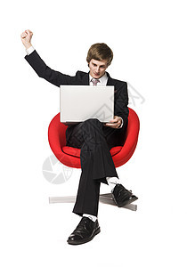 一个带着笔记本电脑的快乐男孩股票交易工作挣钱扑克男性男人套装库存领带背景图片