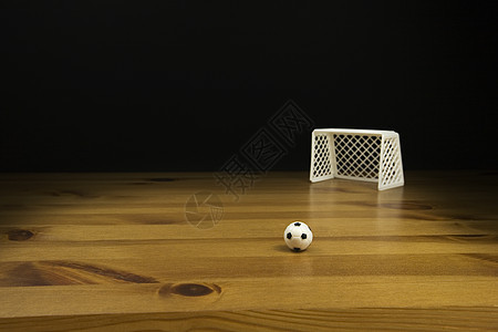 在木桌上贴近一张表 顶尖的足球和球门柱摄影影棚背景深色桌子水平图片