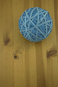 蓝色橡胶带球在木制桌子上的高视图图片