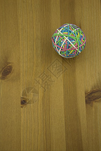 木制 t 上多色橡胶带球的更高视图图片