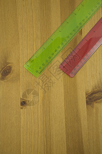木制桌子上红色和绿色标尺的更高视图图片