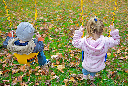 两个小孩坐在秋千里图片