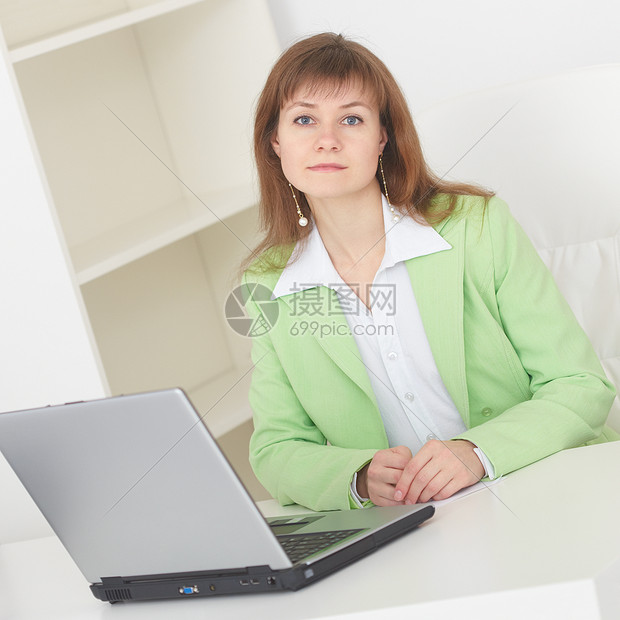 年轻妇女用笔记本电脑坐在轻办公室的桌子上经理互联网商务衣领女士女孩扶手职场女性椅子图片