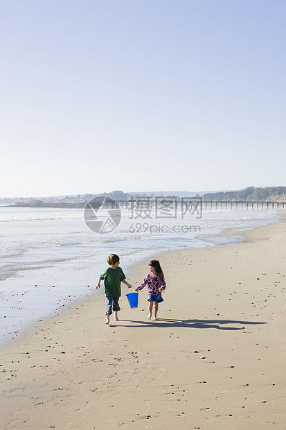 海滩儿童波浪享受孩子兄弟姐妹海洋友谊童年姐姐青少年天空图片