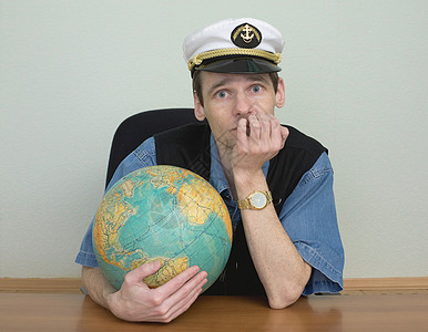 年轻人在船长的海帽上 带着地球图片