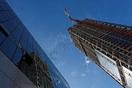塔吊机正在建造的起重吊机和高楼 反映在另一栋大楼中背景