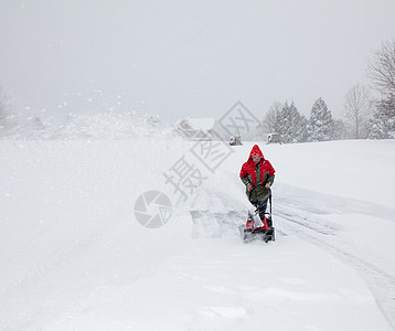 男子在雪车上使用吹雪机红色季节性力量季节天气白色鼓风机暴风雪风暴夹克图片