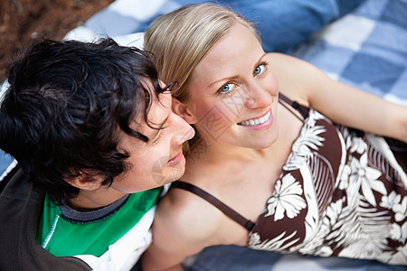 男士西服年轻夫妇在野餐毯子上放松背景