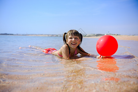海滩上的女孩幸福微笑气球冲浪飞溅太阳童年旅行假期边缘图片