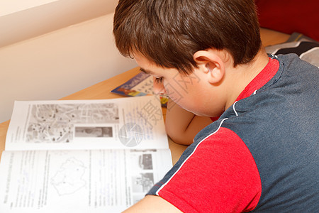 男孩做家庭作业 阅读工作手册的图片