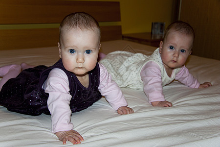 双胞胎躺在床上快乐孩子女孩姐妹白色童年微笑乐趣背景图片