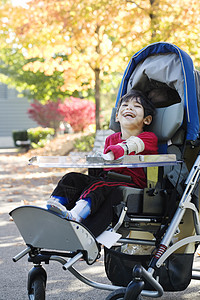 户外医疗婴儿车内残疾男孩乐趣手臂人士公园微笑夹板季节孩子享受机动性图片