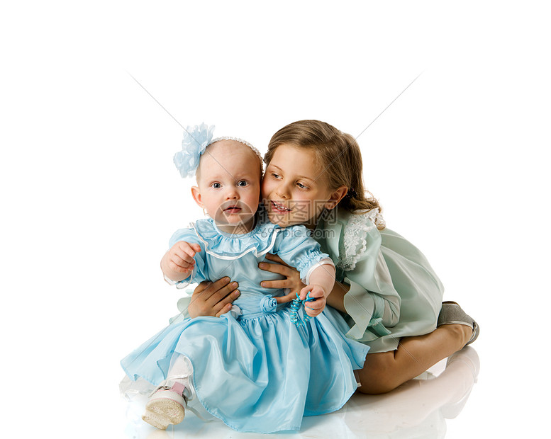 两姐妹会姐妹微笑孩子乐趣冒充孩子们拥抱地面工作室小学生图片