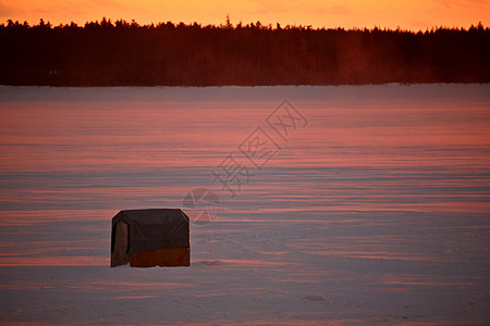 日落时在冰冻湖上钓鱼小屋水平树木乡村旅行冰钓风景大草原剪影美术图片