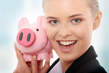 拥有小猪银行的女商务人士喜悦经济投资金融青年生意人银行业蓝色小猪金发图片