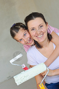 母亲和杜瑟人用滚动画墙壁涂层刷子财产滚筒女士快乐孩子蓝色夫妻梯子图片