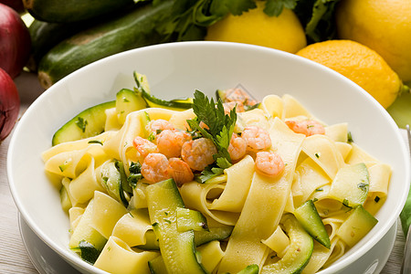 与Zucchini和Shrimps的面食树叶叶子动物香菜甲壳类餐巾胡椒食物柠檬木桌图片