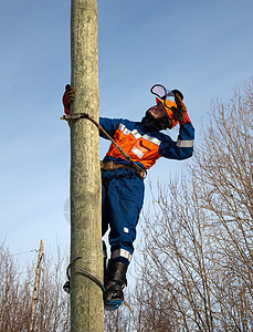 电工在一杆上服务工作工作服天空登山者电压线工维修工具力量图片