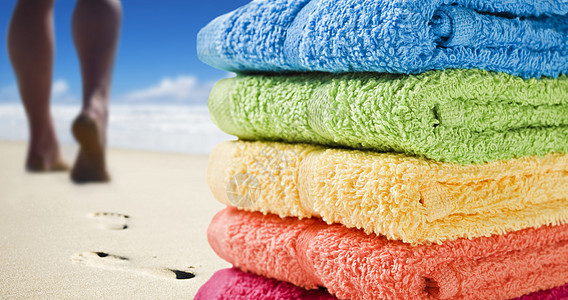 彩色毛巾和有人在海滩上行走图片