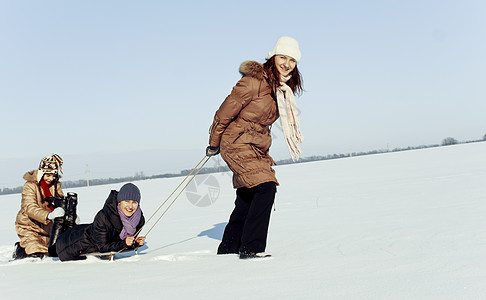 三个快乐的姐妹在冬天滑雪青少年天气平底女孩们帽子乐趣闲暇青春期女性雪橇图片