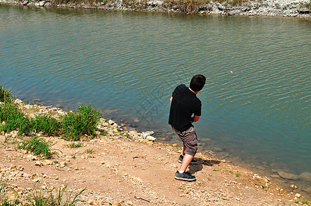 少年在河上跳过岩石图片