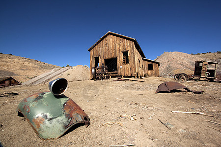 一个生锈的旧卡车护栏 在地面和谷仓 在背面旅行蓝色垃圾乡愁沙漠历史木头衰变窝棚风化图片