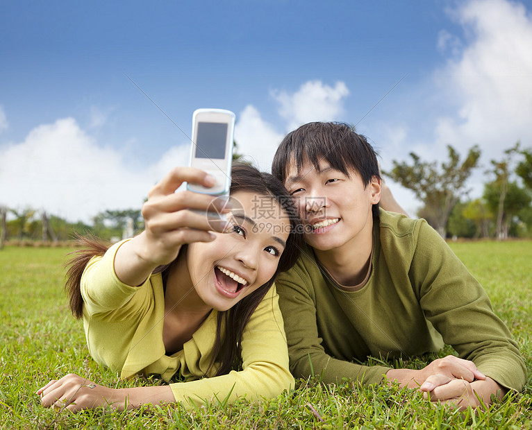 使用智能手机拍摄相片的亚裔夫妇图片