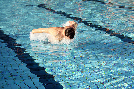 年轻运动运动员在游泳池里游泳图片