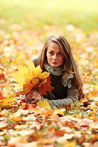 秋叶中的妇女脚尖成人女孩感恩幸福毛衣季节乐趣公园微笑头发图片