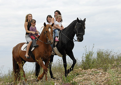 骑自行车的家庭成员金发马匹女儿母亲朋友们幸福宠物孩子们黑色运动背景图片
