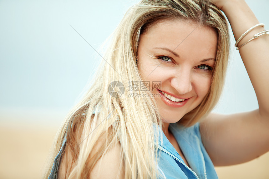女人睡在沙滩上喜悦闲暇金发海滩蓝色旅行头发快乐休息女性图片