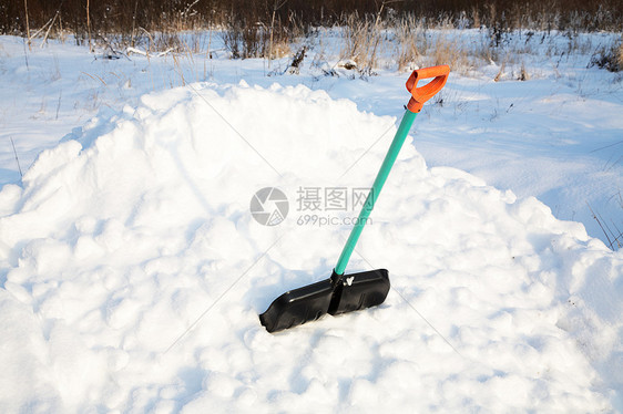 雪地上用铲子擦雪棍图片