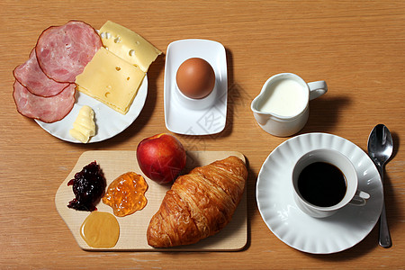 奶酪早餐桌羊角李子桌子勺子橙子环境香肠盘子咖啡蜂蜜背景