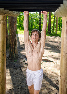 在森林的酒吧 吸引人的男人拉拉训练肌肉力量运动员健美成就男性手臂重量运动图片