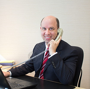 接通电话的商务人士正装讲话电脑沟通男性白领套装管理人员商业微笑图片