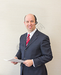 戴耳头和文件的商务人士文档管理人员电话正装首席耳机企业家套装老板男性图片