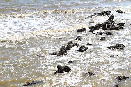 热带海滩上的石头地平线支撑岩石太阳卵石海洋海浪场景碎石异国图片