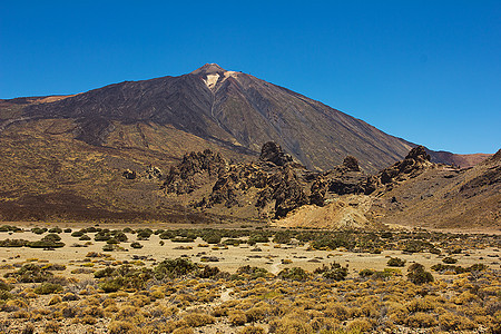 台德山或El Teide的锥火山擦洗月球顶峰天空衬套蓝色岩石巨石火山口游客图片