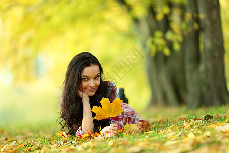 秋叶中的妇女脚尖季节感恩头发成人金发女郎叶子女士乐趣眼睛女性图片