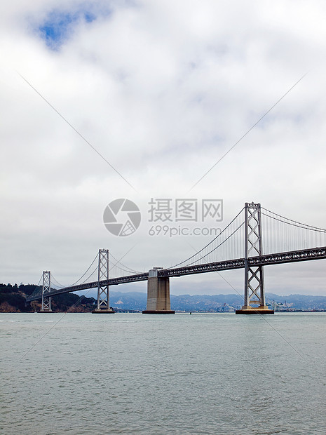 旧金山湾大桥在云天建筑工程城市旅行电缆历史性运输水路地标天空图片